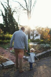 pexels-photo-691047-691047 A heartwarming scene of a father and son walking hand in hand at sunset in a park.